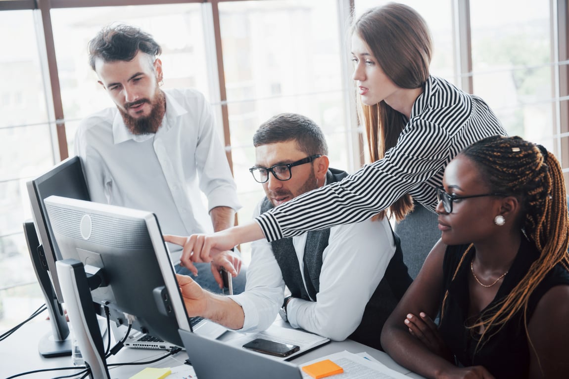 young-employees-sitting-office-table-using-laptop